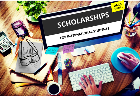 Bild eines Arbeitsplatzes mit Computer. Auf dem Desktop stehen groß die Worte "SCHOLARSHIPS FOR INTERNATIONAL STUDENTS".