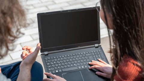 zwei Personen mit Laptop