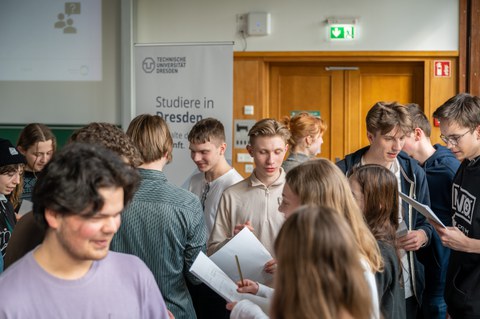 Schüler:innen stehen in großer Gruppe und unterhalten sich.