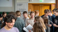 Schüler:innen stehen in großer Gruppe und unterhalten sich.