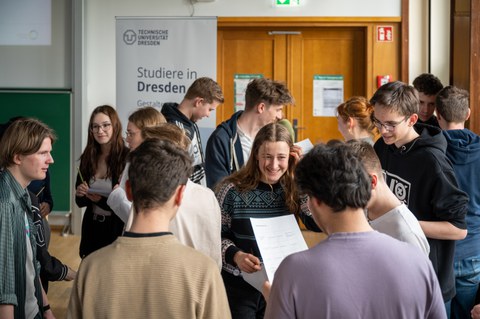 Schüler:innen stehen in großer Gruppe und unterhalten sich.