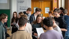 Schüler:innen stehen in großer Gruppe und unterhalten sich.