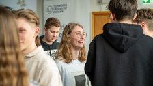 Schüler:innen stehen in großer Gruppe und unterhalten sich.