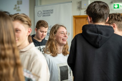 Schüler:innen stehen in großer Gruppe und unterhalten sich.