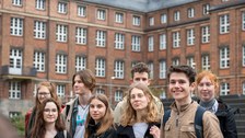 Gruppe von Jugendlichen vor einem Backsteingebäude.