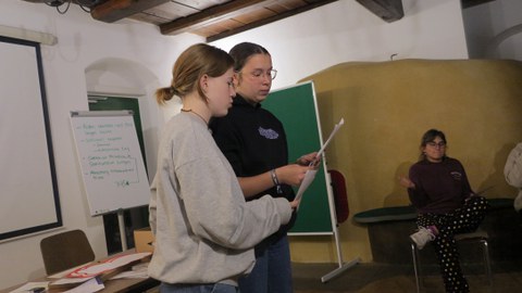 Zwei Schülerinnen tragen eines ihrer selbstgeschriebenen Lieder vor.