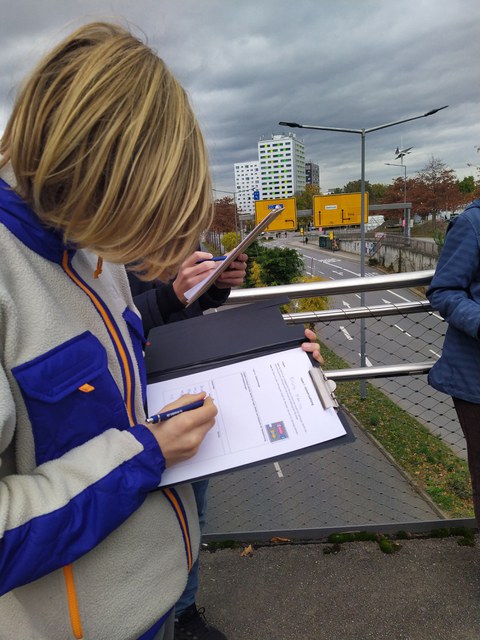 Die Schüler:innen stehen auf der Brücke und nehmen Verkehrsdaten auf.
