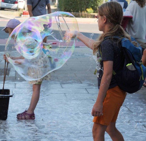 Bild von Kindern, die große Seifenblasen machen.