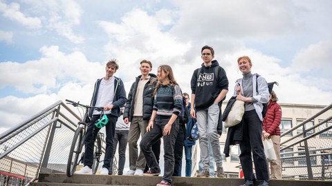 Frühstudierende stehen auf der Brücke vor dem HSZ