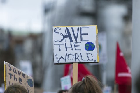 Ein Schild auf einer Demonstration auf dem steht "Save the World"
