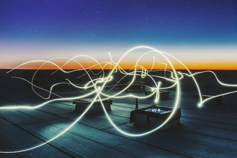 Bild auf dem Dach eines Gebäudes. Lichtlinien zieren das Bild.