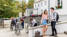 Das Foto zeigt Studenten und Fahrradfahrer vor der „Alten Mensa“ der TU Dresden.