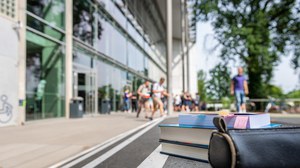 Das Foto zeigt das Hörsaalzentrum der TU Dresden. Im Fokus stehen zwei Bücher und eine Federmappe. Sie liegen auf der Treppe vor dem Hörsaalzentrum