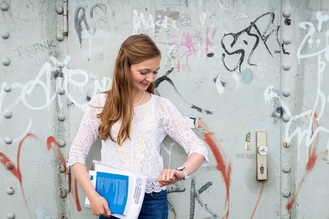 Studentin schaut auf die Uhr