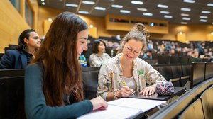 Bilder von Studierenden, die in einem vollen Hörsaal nebeneinander sitzen und sich gegenseitig anschauen..