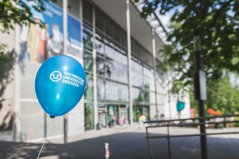 Luftballon mit dem Logo der TU Dresden vor dem Hörsaalzentrum