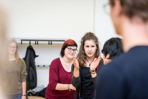 Teilnehmerin übergibt ein Bewegungszeichen an eine andere Teilnehmerin