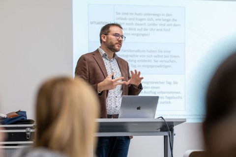 Ein Dozent erklärt einen Sachverhalt zum Thema Zeit