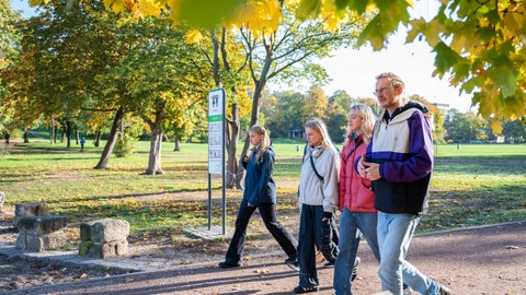Die Teilnehmenden der Herbstuni spazieren durch einen Park