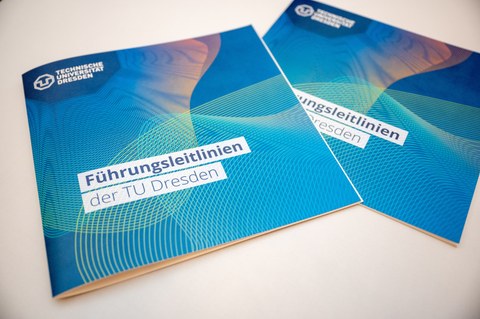 Zwei Broschüren Führungsleitlinien der TU Dresden liegen auf einem Stehtisch.