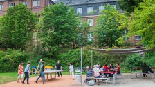 Photo: A group plays table tennis next to the well-attended Grill Cube at the Hörsaalzentrum.