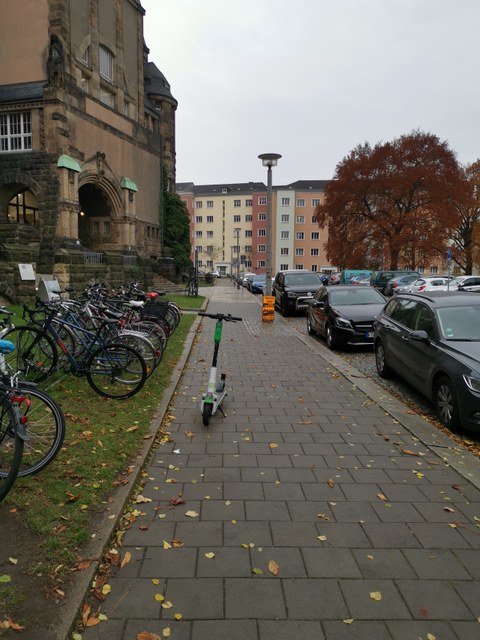 Abgestellter E-Scooter auf dem Fußweg vor dem Schumann-Bau
