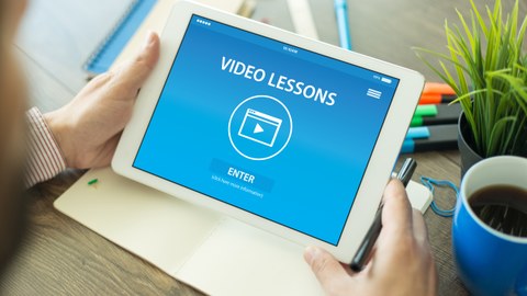 Foto eines Tablets mit einem blauen Bildschirm. Darauf steht "Video Lessons".