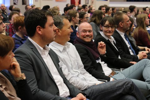 Foto von den Vertretern und Vertreterinnen der Partnerprojekte von BeING Inside. Sie sitzen auf Stuhlreihen und sind seitlich zu sehen, während sie nach vorne schauen.