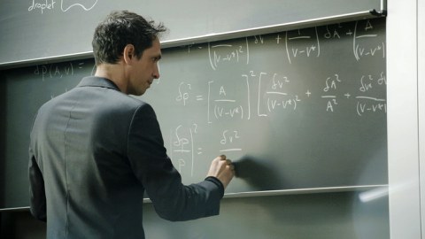 Professor Campàs writes formulas on a blackboard