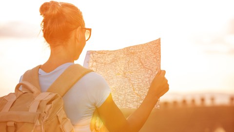Woman with a backpack and a hiking map