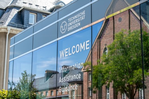 Fot einer verspiegelten Fassade mit dem Logo der TU Dresden und der Aufschrift "Welcome".