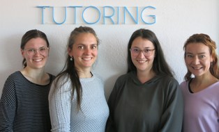 Das Team des Projekts Tutoring als Gruppenporträt (links beginnend: Beatrice Schlegel, Michelle Eichler, Melanie Ludwig, Marina Hüttich) als Halbfiguren vor Koniferenhecke