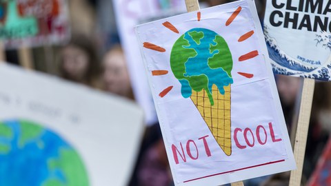 Foto von Menschen mit Protestplakaten gegen den Klimawandel.