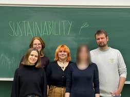 Vier Personen vor einer Tafel mit der Aufschrift "SustainAbility"