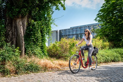 A student rides her bike on campus.