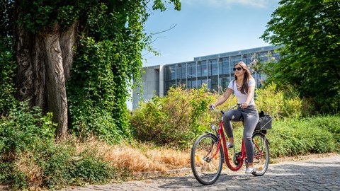 A student rides her bike on campus.