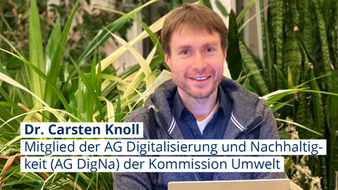 Foto von Dr. Carsten Knoll, der im Schneidersitz vor ein paar Pflanzen sitzt und in die Kamera lächelt, auf seinem Schoß liegt ein geöffneter Laptop