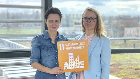 Regine Kramer und Dr. Peggy Freudenberg mit Tafel von SDG 11