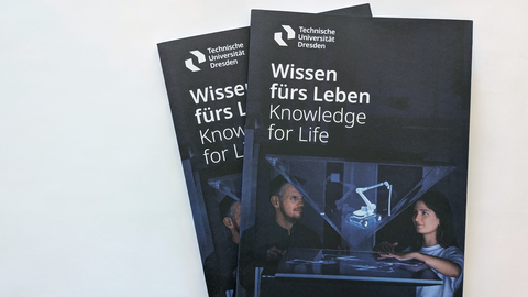 Foto von 2 aufeinanderliegenden Broschüren der TU Dresden mit dem Titel "Wissens fürs Leben".