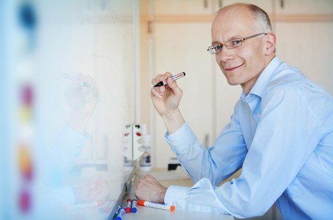 Ein Wissenschaftler schreibt an ein Whiteboard.