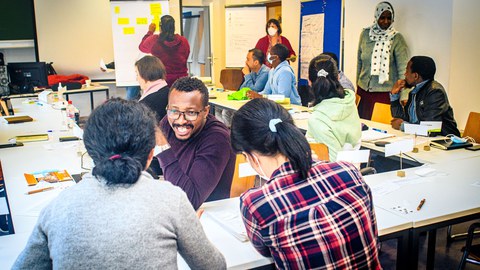 Erwachsene verschiedener Nationen in einem Klassenzimmer