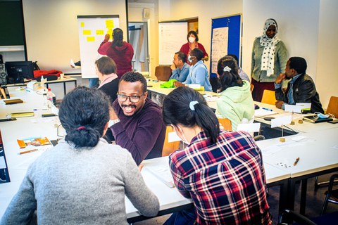 Erwachsene verschiedener Nationen in einem Klassenzimmer