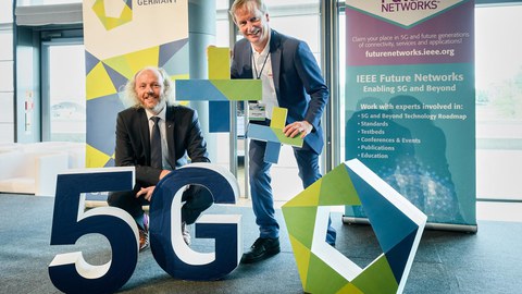 Prof. Fettweis und Prof. Fitzek zwischen Aufstellern 5G ++ und Postern