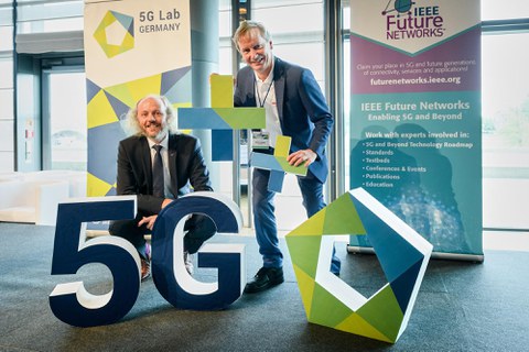 Prof. Fettweis und Prof. Fitzek zwischen Aufstellern 5G ++ und Postern