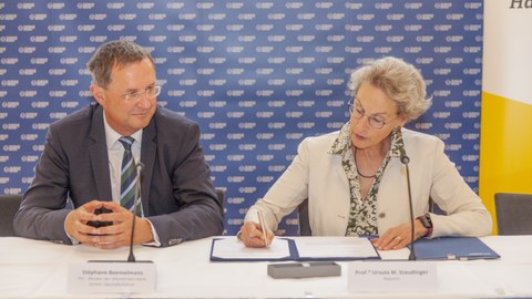 Stephane Beemelmans (links) und Rektorin Prof. Staudinger unterzeichnen den Vertrag.