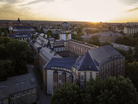 Blick auf das Uni-Gelände mit dem Beyer-Bau im Vordergrund im Zwielicht.