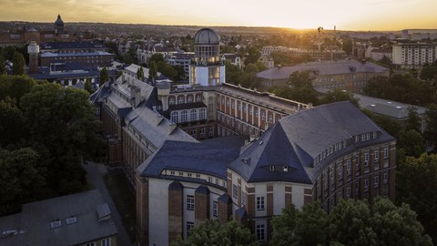 Blick auf das Uni-Gelände mit dem Beyer-Bau im Vordergrund im Zwielicht.