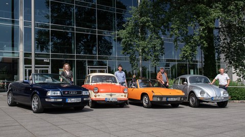 Vier Oldtimer und ihre Besitzer:innen stehen vor dem Hörsaalzentrum.