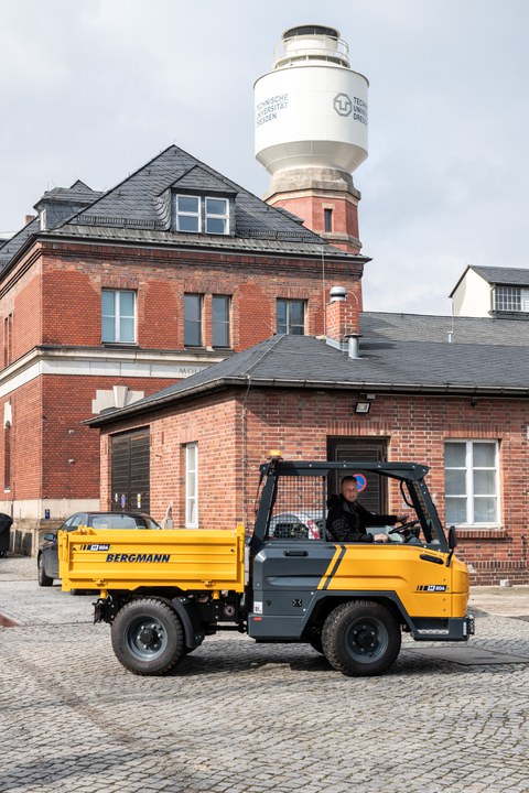 In einem Dumper auf dem TU-Campus sitzt ein Mann.