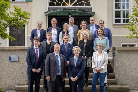 Gruppen von 14 Personen, die sich - versetzt stehend - auf einer Treppe vor dem Eingang des Rektoratsgebäudes der TU Dresden befinden.